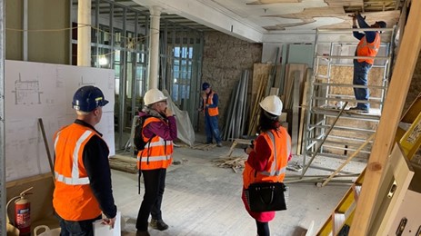 People with hi-vis jackets and hard hats inside Port House building, Jedburgh